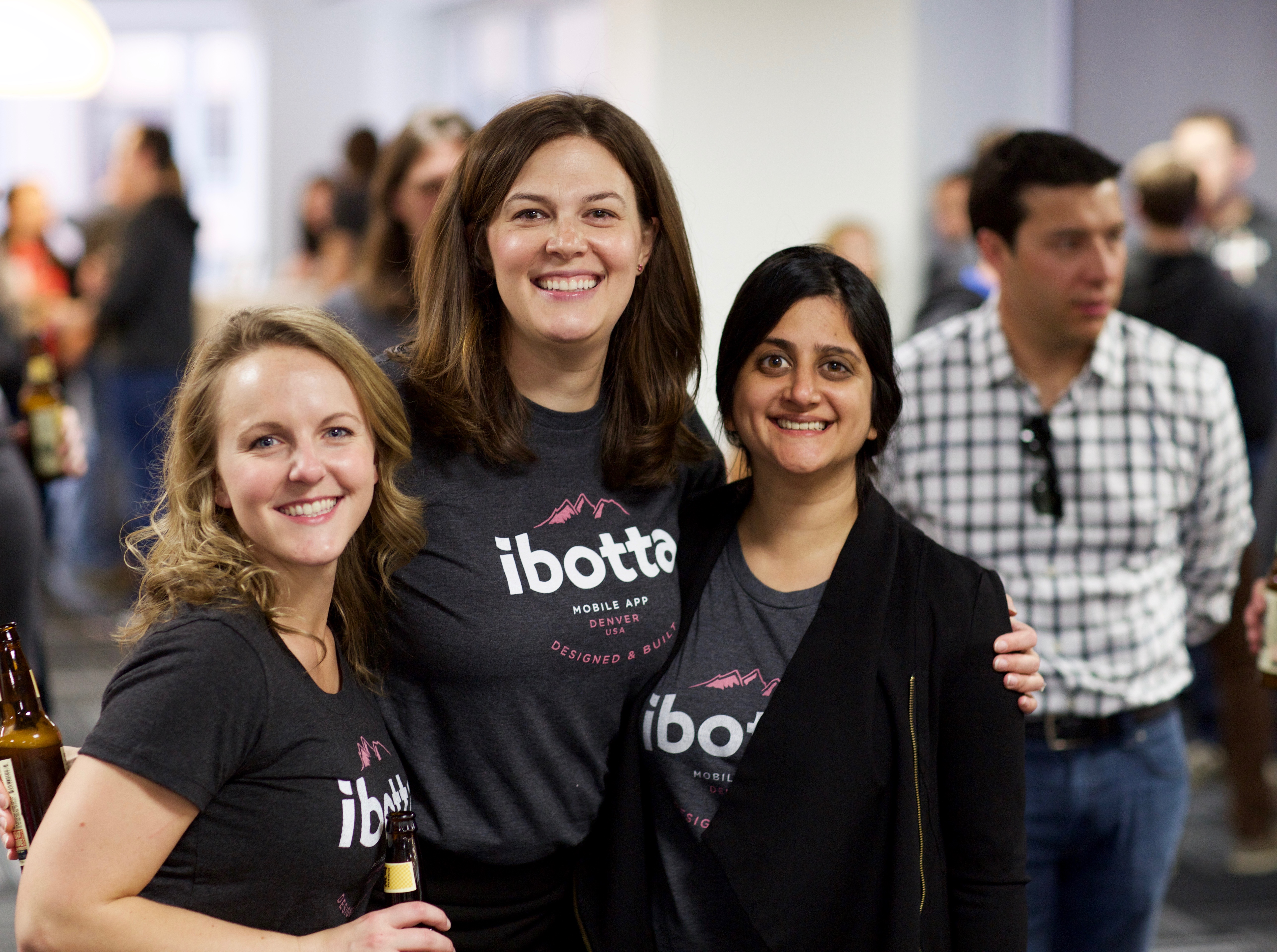 three women with Ibotta tshirts smile in-office
