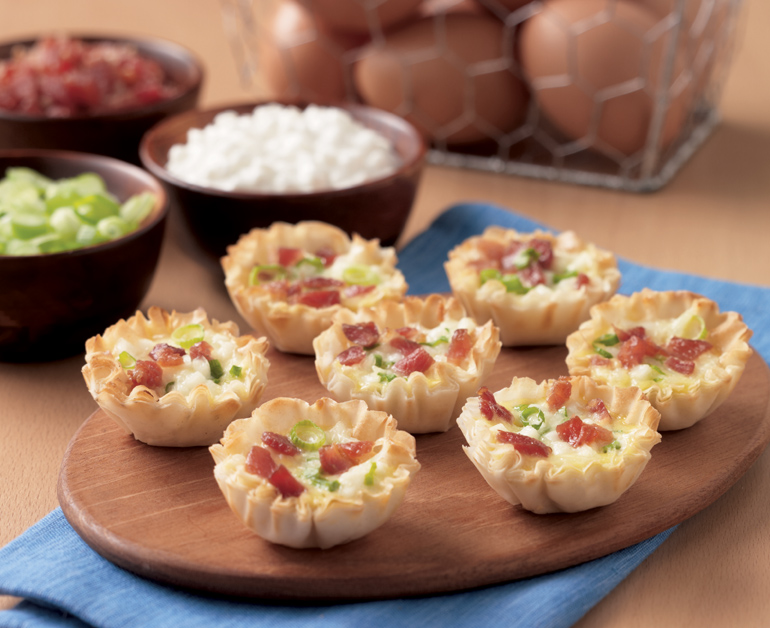 cheesey quiche bites on a wooden platter