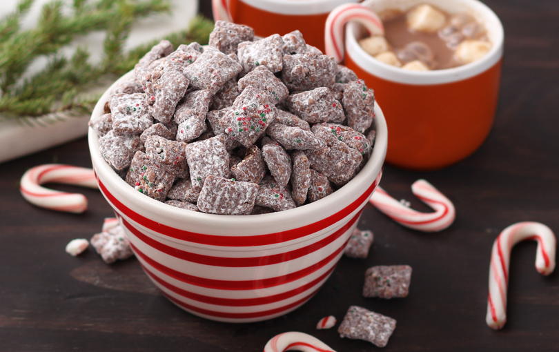 a red and white striped bowl full of muddy buddies