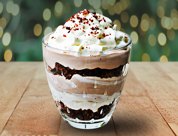 chocolate mousse in layers topped with cream and red sprinkles