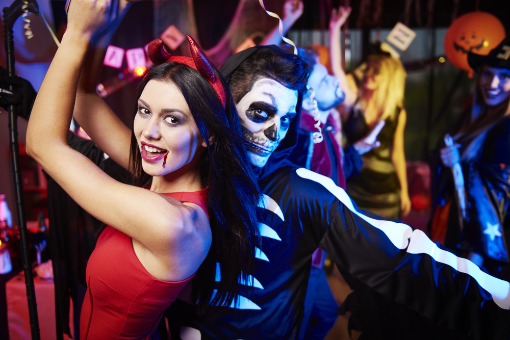 two people dressed in costume dance at a night club
