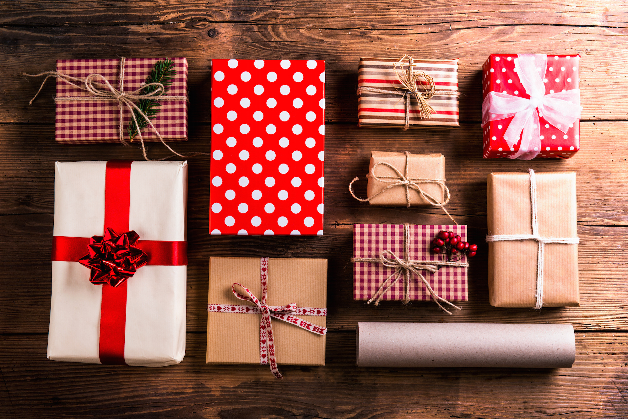 9 variously wrapped gifts in red plaid and polka dots tied with twine
