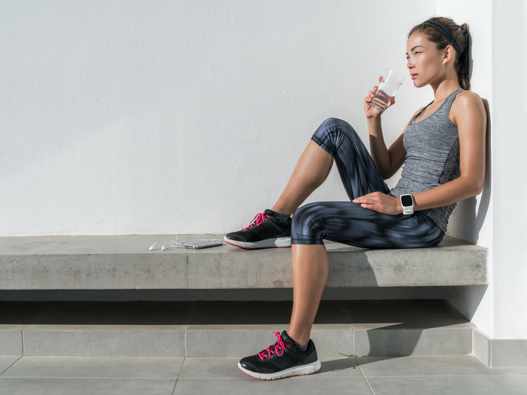 Woman in activewear drinking water