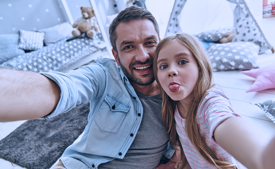 Dad and daughter take a selfie, daughter is sticking out tongue