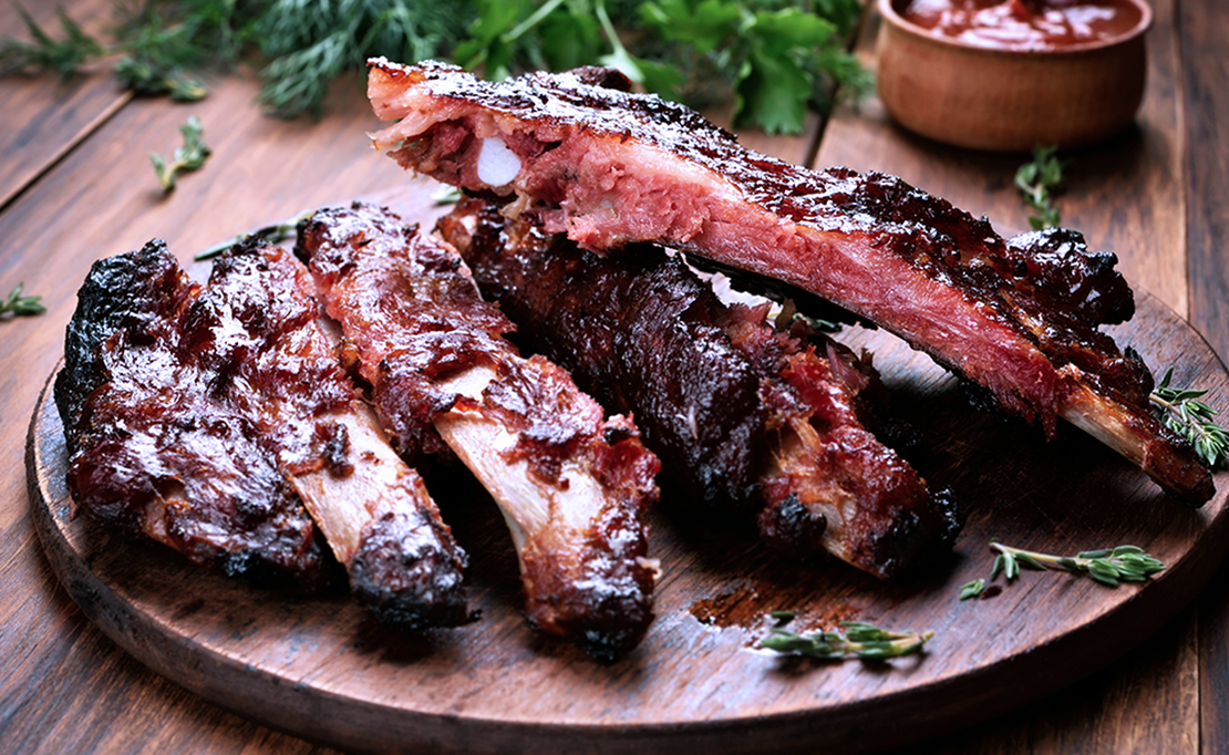 Plate of cooked pork ribs with barbecue sauce