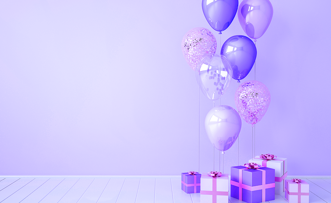 Purple gradient ballons accompany a pile of gifts