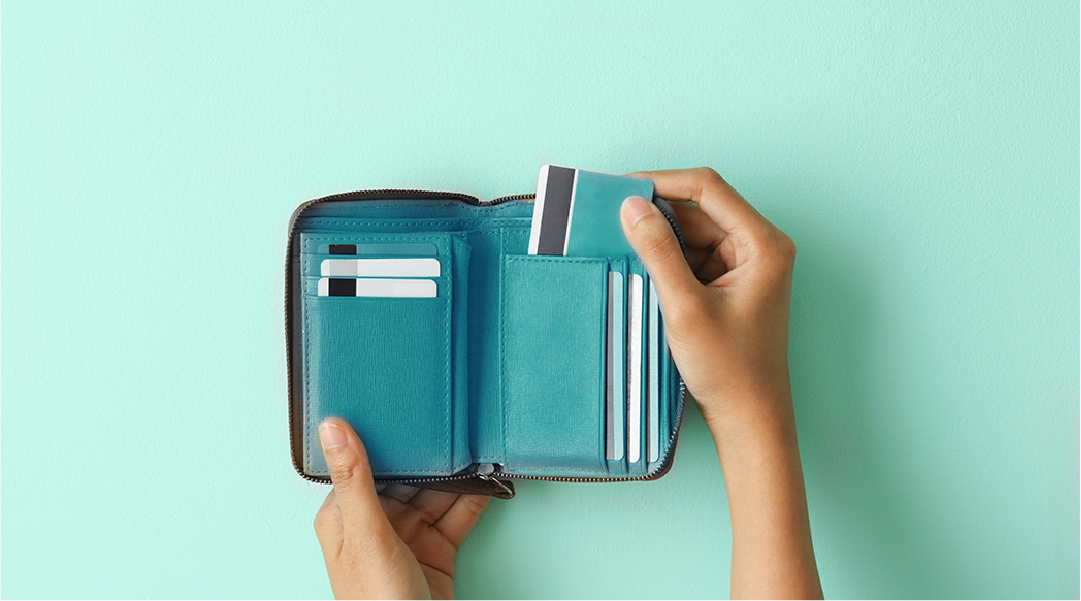 A teal phone wallet is open with a hand pulling out a card