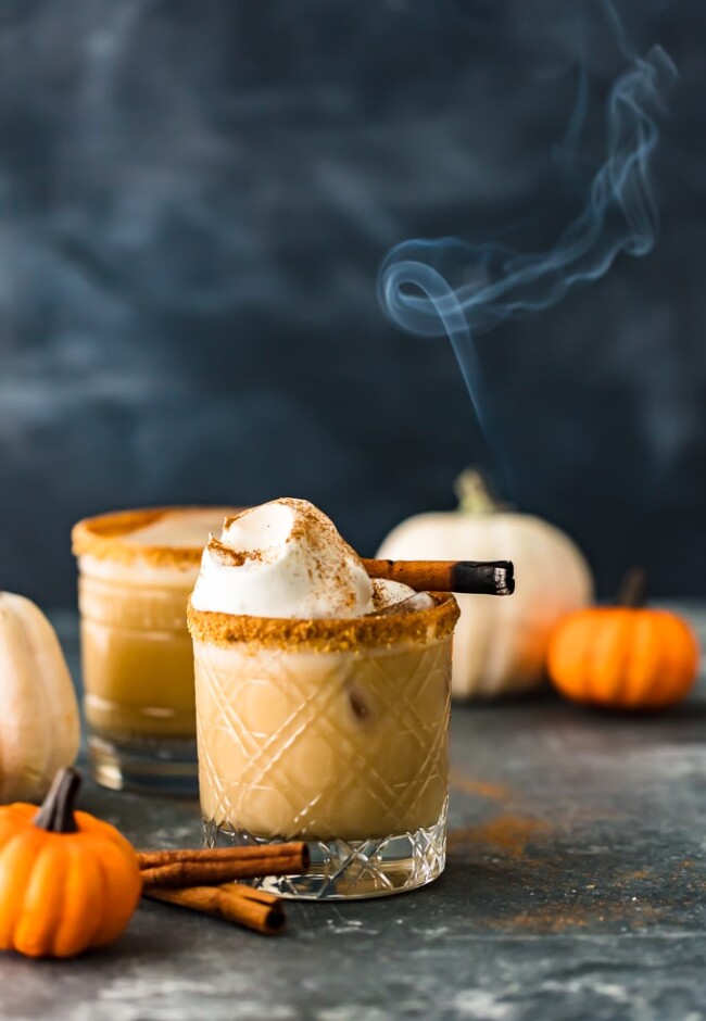 Pumpkin spice white Russian cocktail with a burnt cinnamon stick as garnish