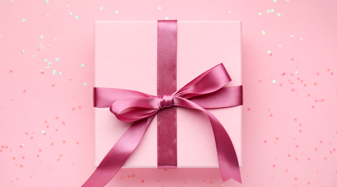 A pink giftbox tied with a dark pink bow