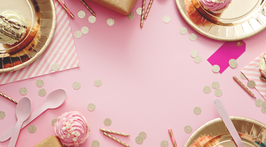 Pink tablescape with gold confetti, pink cupcakes, and hold party hats